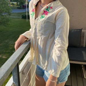 Fin blus med blommiga detaljer  - En fin somrig blus med blommiga detaljer. 