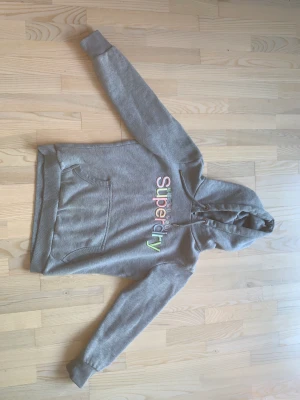 Superdry hoodie - Hoodie från superdry som säljs då den aldrig används. Pris: 200 kr Storlek: EU 42, dvs M (men känns som en S)