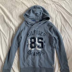 Tommy Hilfiger / Hilfiger Champs Hoodie - Ljusblå - Storlek S / 164 cm - 🐟