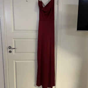 Vinröd klänning  - Vinröd klänning med korsad snörning i ryggen från SHEIN strl XL. Använd en gång. 