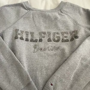 Tommy Hilfinger sweatshirt i storlek XS. Färgen är grå med märket i paljetter. Priset kan diskuteras, fler bilder skriv privat till mig. Köparen står för frakten💖💖