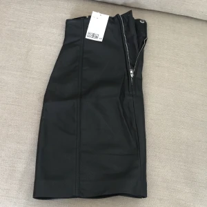 Svart fuskläderkjolstl36 - Ny svart fuskläderkjol stl 36.hm