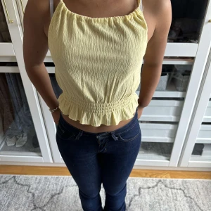 Gul topp med fin rygg  - Super söt gul topp med korsande rygg. Perfekt nu inför sommaren💛