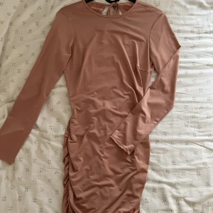 Rosa klänning  - Knälång rosa klänning med öppen rygg från Nelly, toppskick! 