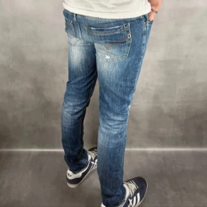 Dondup jeans  - Snygga blå jeans med slitningar och en cool, distressed look. De har en slim passform och är perfekta för en avslappnad stil. Jeansen har klassiska fem fickor och en knappgylf. Skicket är som nya! Han på bilden väger 67 och är runt 178 cm lång!