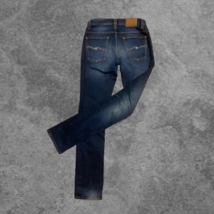 Nudie Jeans Grim trim  - Snygga blå jeans från Nudie Jeans med klassisk femficksdesign och orange sömmar. Väldigt unik tvätt då dem andvänds sparsamt men ändå slitning vid hälen skiner igenom vilket ger dem en snygg look. W29 men passar även 30. Modell: grim trim 