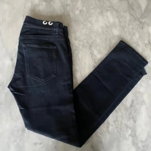 Svarta dondup ritchie jeans W33 - Skick: 8/10. Jeansen är i bra skick och har inga defekter. Från märket dondup i modellen ritchie. Om du är osäker på om det kommer att passa kan du alltid fråga om mått! 