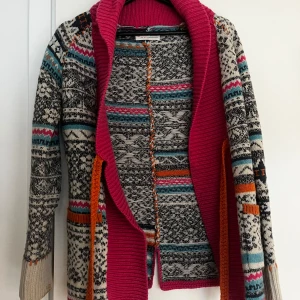 Mönstrad kofta från Odd Molly - Säljer en färgglad och mönstrad kofta från Odd Molly. Koftan har en mix av färger som rosa, turkos, orange och svart med ett unikt mönster. Den har långa ärmar och en öppen design med en bred krage i rosa. Perfekt för att liva upp garderoben!