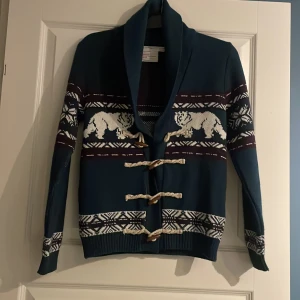 Cardigan tröja - En snygg unik cardigan tröja med sjal krage med många snygga detaljer. Den är vinröd, petrol och vit