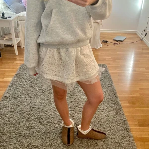 spetskjol - Säljer en helt ny söt offwhite spetskjol med volangdetaljer. Kjolen har en kort längd och är perfekt för att ge en cute touch till din outfit. Den är lätt och luftig, vilket gör den idealisk för varmare dagar. (EJ ANVÄND, prislapp kvar)