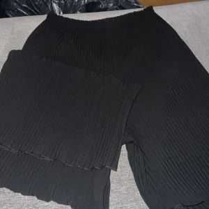 Svarta plisserade byxor - Snygga svarta plisserade byxor med elastisk midja. Perfekta för en stilren look och bekväma att bära hela dagen. Passar bra till både vardag och mer uppklädda tillfällen.
