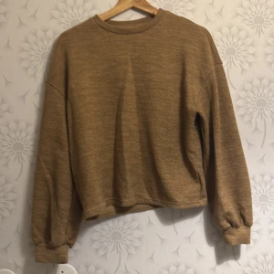 Beige stickad tröja - Säljer en mysig beige stickad tröja med långa ärmar och ribbade muddar. Perfekt för kyligare dagar och ger en avslappnad look. Passar bra till jeans eller leggings.