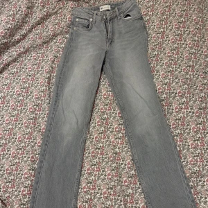 Grå slitjeans Zara - Grå lågmidjade jeans från Zara. Rak modell med slits på insidan längst ner. De är sparsamt använda o kommer inte till användning längre. Storlek 32. Normal storlek 