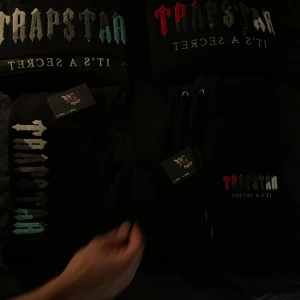 Svart hoodie från Trapstar - Trapstar dress med Hoodie och byxor, den gröna är såld så det är den röda kvar som är helt ny och är i storlek M men passar även S