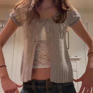 Grå babydoll topp - Säljer en söt grå stickad babydoll kofta vintage från Tally Weijl. Den har korta puffiga ärmar och knappar framtill. Perfekt för lager-på-lager och passar bra till både jeans och kjol💕🤍