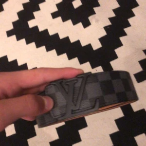 Svart och grått rutigt lv bälte  - Snyggt svart och grått bälte från LV med rutigt mönster och ett stort spänne. Perfekt för att ge din outfit en stilren touch. De är använt ett fåtal gånger och köpte de nyligen o använder knappt så vill bli av me de, skicka dm vid intresse! Priset kan diskuteras vid snabb affär!