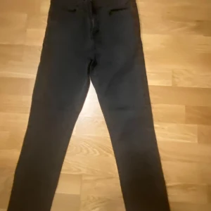 Svarta jeansbyxor - Snygga svarta jeansbyxor med en klassisk design. De har en rak passform och är perfekta för en stilren look. Byxorna har en enkel och tidlös stil som passar till många olika tillfällen.