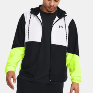 Svart och vit vindjacka från Under Armour - Snygg vindjacka från Under Armour i svart och vitt med neongula detaljer. Jackan har en dragkedja framtill och en justerbar huva. Perfekt för träning eller en aktiv dag ute.  Köpt för 1899 men kan gå ner vid snabb affär