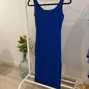 Blå ribbad klänning - Snygg blå ribbad klänning med slits på sidan. Klänningen är ärmlös och har en kroppsnära passform. Är i storlek S och är köpt för 220kr!💓Är helt oanvänd och är som ny!