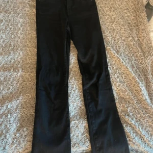 Svarta jeansbyxor - Snygga svarta jeansbyxor med en klassisk design. De har en rak passform, med en liten boutcut och är perfekta för en stilren look. Byxorna har fickor både fram och bak. Haft på mig enbart en gång.