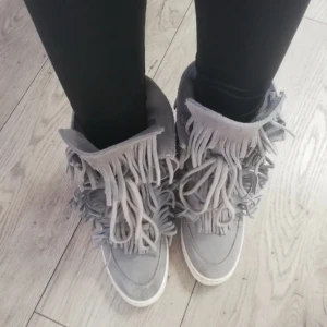 Grå boots med fransar - Snygga grå boots med fransar som ger en bohemisk touch. Perfekta för att lyfta din outfit med en unik stil.