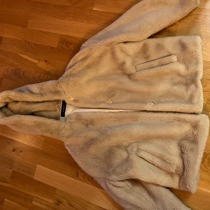 Beige teddyjacka från Zara Basic - Mysig beige teddyjacka från Zara Basic med huva och knappar framtill. Inga defekter eller skador förekommer, storlek S färg: beige. Kontakta mig gärna vid frågor eller intresse!🩷