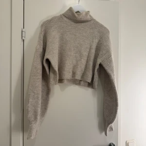 Stickad croppad tröja - Stickad croppad tröja med halv hög hals. Ballong ärmar som e väldigt fina. Använd några gånger men är i fint skick utan vidare tecken på amvändning. Storlek S