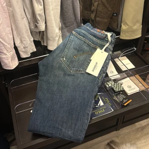 Dondup Jeans George - Snygga blå jeans från Dondup med klassisk femficksdesign och subtila slitningar. De har en rak passform och är perfekta för en avslappnad stil. Jeansen har en dragkedja och knappstängning. Modellen heter George. Otroligt snygg tvätt och dessa är helt nya med prislappen på fortfarande. Kvitto tillkommer också. Nypris på dessa ligger på 3900kr mitt pris är nu endast 1199kr alltså mer än halva priset på dessa helt sjuka jeans. Köp medan det fortfarande finns kvar!