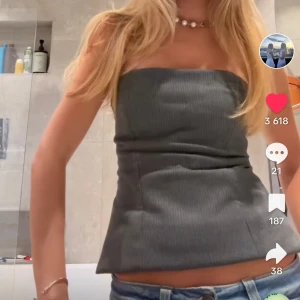 Grå ribbad tubtopp - Snygg grå ribbad tubtopp som sitter tight och är perfekt för en stilren look. Toppen är axelbandslös och har en enkel design som gör den lätt att matcha med olika outfits. Från zara.