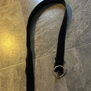svart bälte med guldigt spänne - stilrent och snyggt, 6st hål. fråga om längd så fixar jag. lite lossnat på npgrs ställen men går att limma ihop