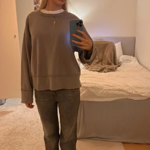Grå oversized sweatshirt - Säljer en grå oversized sweatshirt med långa ärmar. Tröjan har en avslappnad passform och ribbade muddar vid ärmsluten. Perfekt för en casual look.