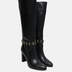 Svarta stövlar med nitar - Snygga svarta stövlar i skinn med dekorativa nitar runt ankeln och en elegant klack. Perfekta för att ge din outfit en edgy touch. Finns i två olika storlekar EU-30 och EU-40.  