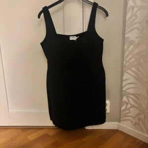 Svart korsettklänning från Claire Rose - Snygg svart korsettklänning från Claire Rose med breda axelband. Perfekt för en elegant look. Klänningen är i en klassisk svart färg och har en figurnära passform.