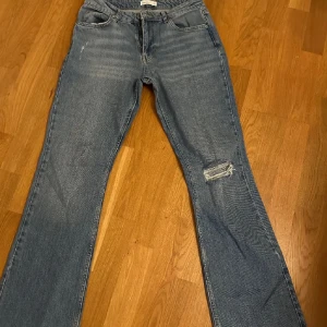 Blå jeans med slitningar - gina tricot full lenght flare jeans, storlek 38, använt fåtal gånger. nypris 499kr😊