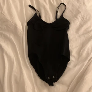 Svart body  - Snygg svart body  med smala axelband, dem är även justerbara. Enkel och elegant stil som passar alla tillfällen. Antingen köpa varan för de priset som anges eller byta ut den för något annat