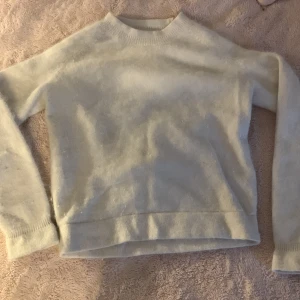 Vit stickad tröja - Mysig vit stickad tröja med rund hals och långa ärmar. Perfekt för kyliga dagar och enkel att matcha med olika outfits.
