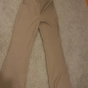 Begie kostymbyxor från Bik Bok - Snygga begie kostymbyxor från Bik Bok i storlek L Byxorna har en klassisk design Perfekta för en chic och elegant stil. Helt nya oanvända 