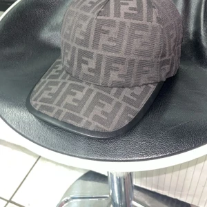 Fendi keps  - Snygg Fendi keps med ett distinkt mönster. Perfekt för att ge din outfit en stilfull touch. Kepsen har en klassisk design med böjd skärm och justerbar passform.