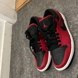 Nike Air Jordans i rött och svart - Snygga Nike Air Jordans i rött och svart med klassisk snörning och vit sula. Perfekta för dig som vill ha en stilren och sportig look. Ikonisk Jumpman-logga på plösen.