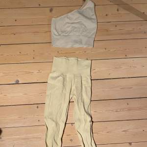 Snygg gul oneshoulder topp med ribbad struktur. Gjord för träning men perfekt för en stilren och modern look. Matcha med dina favoritjeans eller kjol för en komplett outfit. Matchande underdel tillkommer .