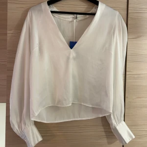 Vit blus  - En vit blus från Nelly. Köpte på Sellpy för ett tag sedan men aldrig kommit till användning då jag har flera liknande. Lite tunnare i tyget som syns på andra bilden eftersom lappen lyser igenom. 