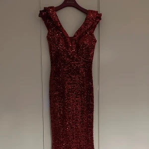 Vinröd paljettklänning - Snygg vinröd klänning täckt med glittrande paljetter. Den har en v-ringad design och breda axelband. Perfekt för en festlig kväll ❤️‍🔥