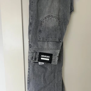Grå cargopants från Dr Denim - Snygga grå cargopants från Dr Denim med praktiska fickor på sidorna. Perfekta för en avslappnad stil. Byxorna har en modern design och är tillverkade i ett slitstarkt material.