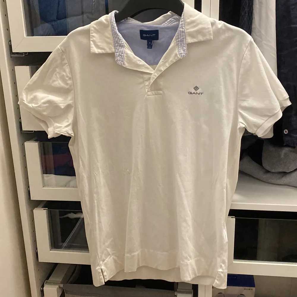 Säljer en stilren vit pikétröja från GANT i storlek S. Tröjan har korta ärmar och en klassisk krage med diskret logotyp på bröstet. Perfekt för en avslappnad och snygg look. Tröjan är knappt använd och väldigt gott skick!. T-paidat.