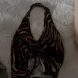 Mönstrad halterneck topp från Shein - Snygg halterneck topp från Shein med ett coolt mönster i brunt, svart och beige. Toppen har en knytning framtill och är perfekt för en trendig look.