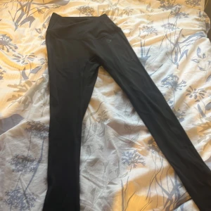 Svarta leggings från Gymshark - Snygga svarta leggings från Gymshark med korsad midja. Helt nytt skick, säljer dessa eftersom dem inte passar mig