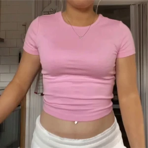 Rosa croppad t-shirt - Säljer en söt rosa croppad t-shirt med korta ärmar. 