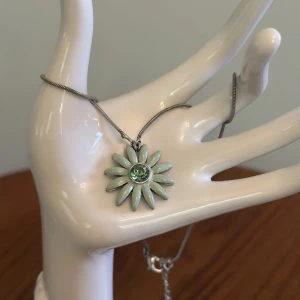 Halsband från pilgrim - Ett så vackert halsband från pilgrim med en grön blomsterberlock med en grön diamant i mitten. 