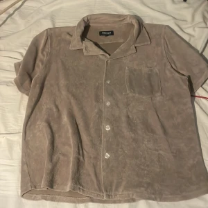 Beige kortärmad skjorta från Nikben - Säljer en stilren beige kortärmad skjorta från Nikben. Skjortan har en klassisk krage och knappar framtill. Perfekt för en avslappnad look. 🕶️