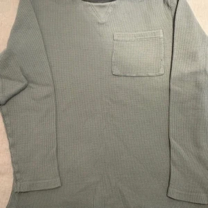 Grön långärmad tröja från Cubus - Säljer en grön långärmad tröja från Cubus i ekologisk bomull. Tröjan har en bröstficka och en bekväm passform. Perfekt för en avslappnad stil. 🌿